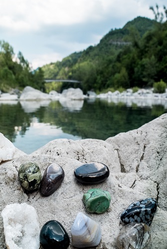 pierres de lithothérapie près d'une rivière et montagne à l'arrière plan